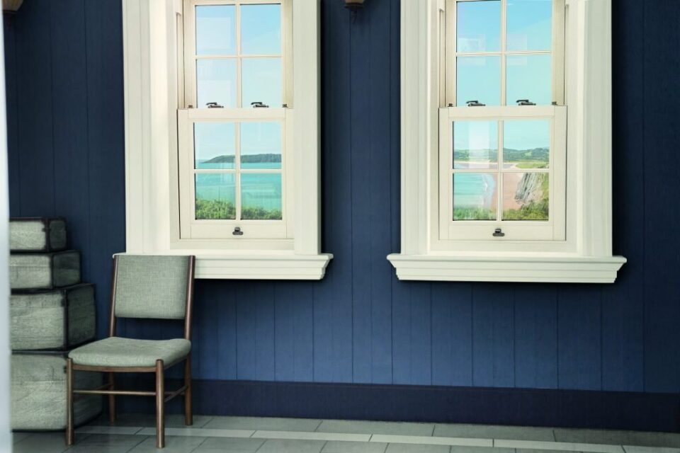 Two white VEKA Imagine sliding sash windows in a room with navy panelled walls